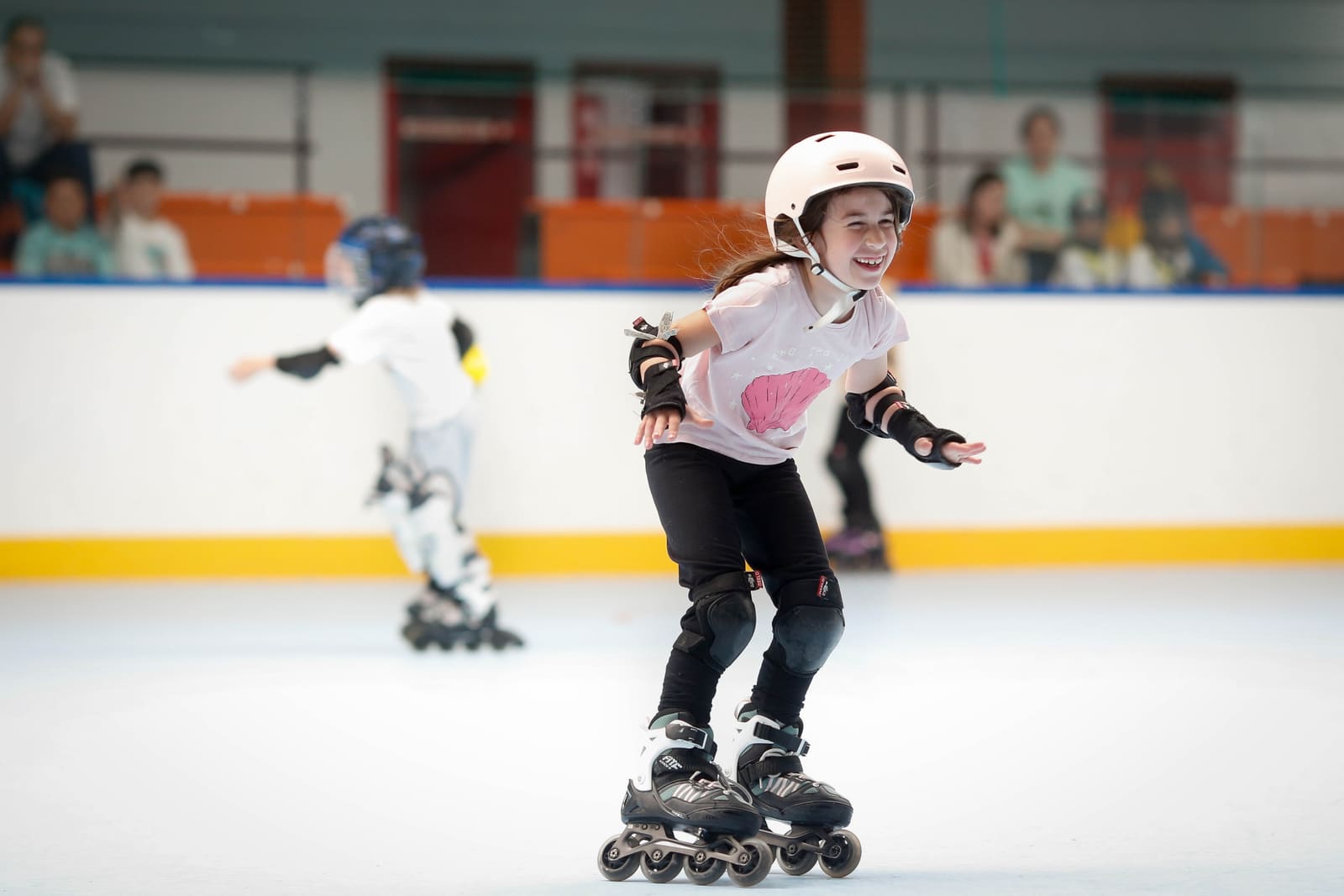 Dos peques de la escuela patinando juntas y riéndose