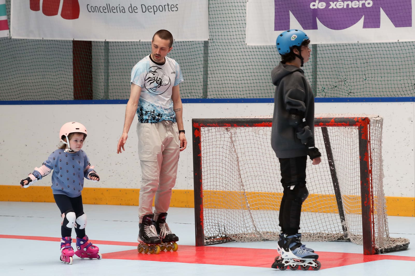 Un monitor del CHL Meigas acompañando a una peque que da sus primeros pasos sobre patines