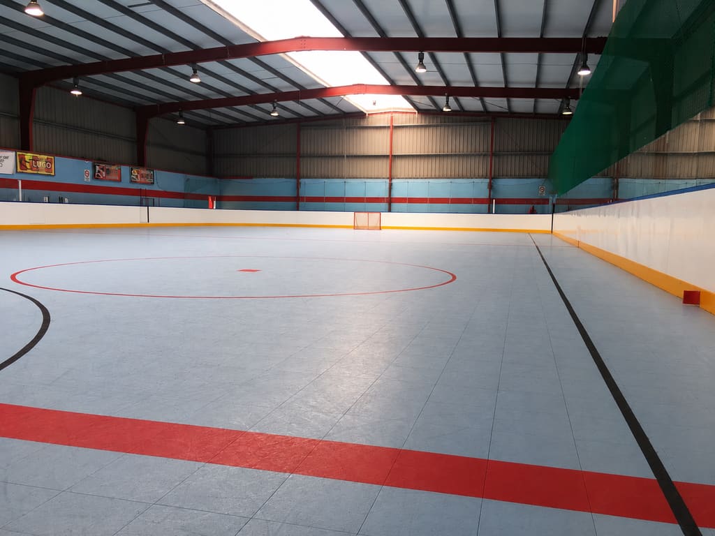 Pista cubierta del Polideportivo Daniel Cordido, con suelo Sport Court y vallas de hockey alrededor